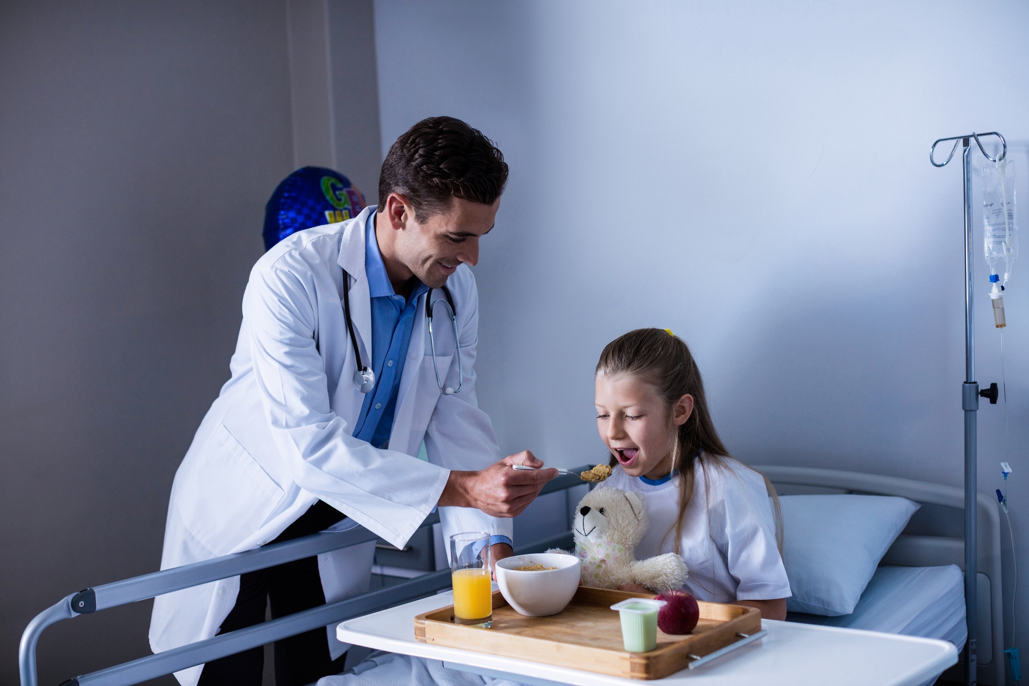 Doctor feeding breakfast to patient